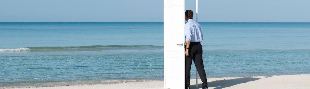 Man walking into open door on beach, rear view