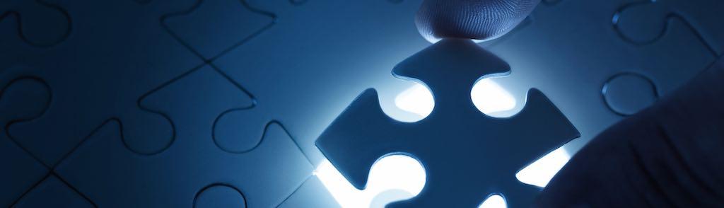 Business concept, male hand putting missing piece of jigsaw puzzle with copy space