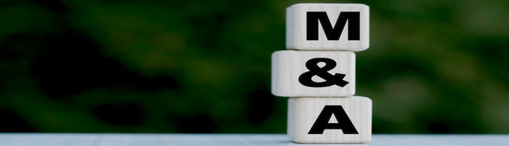 The concept of the word M&amp;A on cubes on a beautiful green background. Business concept