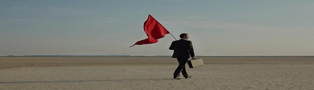 Businessman holding a red flag